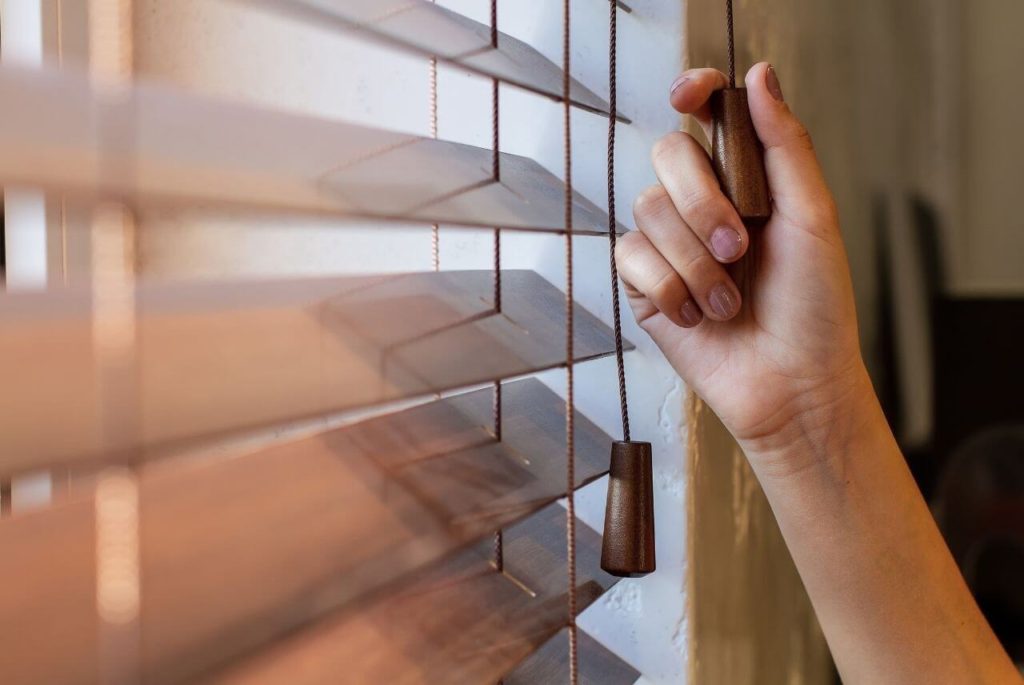 Wood blinds pulling up using its cord